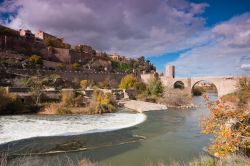 Toledo e le rive del Tago in autunno, con la sagoma del Ponte di Alcàntara sullo sfondo. Costruito dagli arabi e rimesso a nuovo dai romani, nel medioevo era una delle porte d'ingresso ...