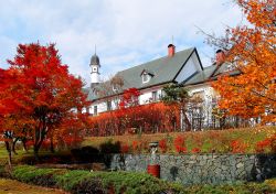 Paesaggio autunnale con aceri rossi vicino all'edificio dello Snow Crystal Museum a Asahikawa, Giappone. Questo singolare museo dedicato ai fiocchi di neve è ospitato in un piccolo ...