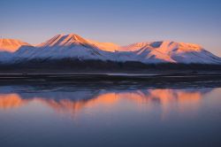 Paesaggio con tramonto rosa sulle montagne di Spitsbegen, isole Svalbard, riflesso nelle acque del mare. Siamo nei pressi della città norvegese di Longyearbyen.