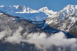 Paesaggio primaverile dello ski resort de La Rosiere, Francia, con le montagne innevate sullo sfondo e la foschia in primo piano. 
