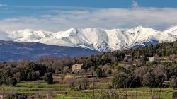 Paesaggio primaverile nei pressi della città di Olot, Spagna. Sullo sfondo, le montagne ancora innevate.

