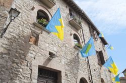 Un palazzo medievale con bandiere rionali a Corciano di Perugia - © Mi.Ti. / Shutterstock.com