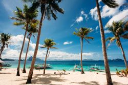 Palme, barche filippine, sabbia bianca e acqua turchese: siamo in una delle spiagge di El Nido (isola di Palawan).




