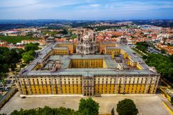Panorama aereo del Convento Reale e del Palazzo di Mafra, Portogallo. Principale attrazione della città, questo complesso ospita al suo interno più di 1200 stanze collegate da ...