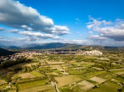 Panorama aereo di Posada, borgo della Baronia, Sardegna. Arroccato su una rupe, questo villaggio è dominato da un castello e ai suoi piedi si estende una valle verde che sfocia nel fiume ...