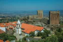 Panorama dall'alto della città di Linhares da Beira, Portogallo: i tetti delle case, le mura del castello con le torri fortificate e il campanile della chiesa.

