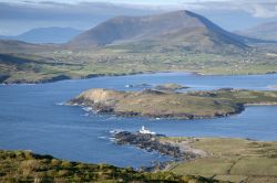 Un panorama dall'alto di Valentia Island con il faro da Geokaum Mountain, Irlanda. Con i suoi 266 metri è la montagna più elevata dell'isola irlandese.



