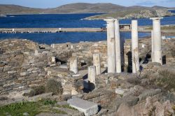 Panorama dall'alto sulla casa di Cleopatra a Delos, Grecia. Le colonne di marmo bianco si stagliano sullo sfondo blu azzurro del Mare Egeo che lambisce le coste di quest'isola un tempo ...