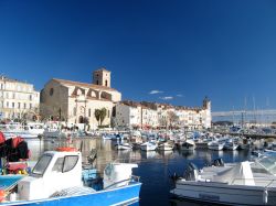 Panorama del porto di La Ciotat, Francia, con le barche ormeggiate e i palazzi antichi sullo sfondo.
