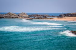 Panorama della spiaggia di Helgueras, Noja, Cantabria, Spagna. A protezione del litorale sabbioso vi sono formazioni rocciose, habitat per diverse specie di fauna ittica.
