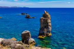 Panorama delle rocce vulcaniche note come Le Colonne a Carloforte, isola di San Pietro, Sardegna. Dal mare blu s'innalzano due pilastri naturali di colore grigio scuro in uno scenario fatto ...