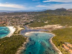 Panorama di località Bados, Olbia, Sardegna, con il litorale sabbioso e le montagne sullo sfondo.

