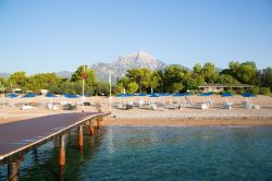 Panorama di spiaggia e pontile in legno a Tekirova, Turchia, con il Monte Olimpo sullo sfondo.

