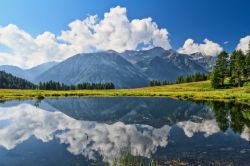 Panorama estivo sul lago Covel nella valle di Pejo, Trentino Alto Adige. Raggiunto il centro abitato di Pejo, nei pressi della chiesa si risale una ripida strada asfaltata sino al dosso di San ...