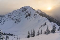 Panorama innevato delle montagne nei pressi di Golden, Canada, all'alba con foschia.



