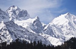 Panorama innevato dell'Himalaya sopra Kullu Valley, stato dell'Himachal Pradesh, India. La vallata Kullu è celebre per  i suoi templi e per le maestose colline ricoperte ...