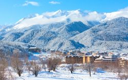 Panorama invernale dello ski resort di Bansko, Bulgaria, con chalet in legno e palazzi.



