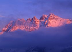 Panorama mattutino sulle vette di Les Crosets, Svizzera: un pittoresco bagliore rossastro illumina le cime della stazione sciistica nel Cantone del Vallese.
