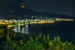 Panorama notturno di Tucepi, Crozia. Situata nel cuore della riviera di Makarska, questa graziosa località di mare è protetta dalle pendici del monte Biokovo.

