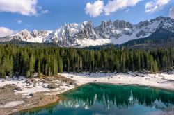 Panorama primaverile dell'incantevole lago di Carezza e il Massiccio del Latemar sullo sfondo (Trentino Alto Adige).
