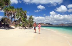 Papà e figlia corrono su una spiaggia delle isole Gili, Lombok, Indonesia.



