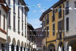 Particolare di una strada in centro a Abbiategrasso. Il comune lombardo è famoso per i suoi portici del centro, costruiti nel tempo con differenti stili architettonici - © Claudio ...