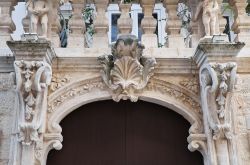 Particolare scultoreo di Palazzo Antonelli a Rutigliano, Puglia. I capitelli finemente decorati impreziosiscono l'elegante facciata di questo storico edificio cittadino.
