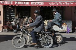 Antico e moderno a Marrakech, Marocco - Una simpatica immagine scattata nel centro di Marrakech che ritrae il contrasto fra passato e presente: qui ci si sposta in moto ma anche su carretti ...