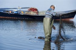 Un pescatore con le reti nel porto di Sant'Antioco in Sardegna - © Famed01 / Shutterstock.com 