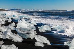 Pezzi di ghiaccio sulla sabbia nera della Diamond Beach, la spiaggia antistante la Jokulsarlon, al tramonto (Islanda).



