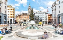Piazza Monte Grappa nel centro storico di Varese, Lombardia. Un abete e una fontana dominano la piazza costruita nel 1927 all'epoca del regime fascista su progetto dell'architetto Loreti ...