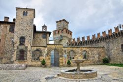 Il piazzale con fontana del Castello di Vigoleno. La struttura vanta probabilmente circa 1000 anni di soria, anche se i primi documenti lo citano nel 12° secolo - © Mi.Ti. / Shutterstock.com ...