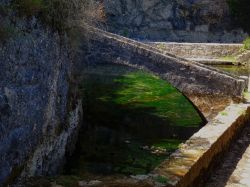 Un piccolo ponte in pietra sulle sorgenti naturali "Les chartreux" a Cahors, Francia.
