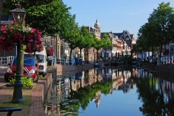 Pittoresca veduta di un canale fiorito a Leiden con le tipiche case affacciate (Olanda). Il centro storico cittadino ha più di 28 chilometri di canali e corsi d'acqua.

