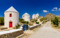 I pittoreschi mulini a vento del borgo di Agia Marina, isola di Lero, Grecia. Sullo sfondo, il castello della città del Dodecaneso.

