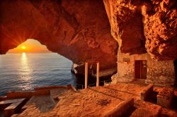 Pittoresco tramonto alla grotta della chiesa di Agios Stefanos, vicino al villaggio di Galissas, isola di Syros, Mare Egeo.

