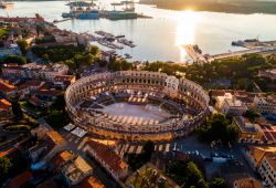 Pola, l'arena fotografata al tramonto dall'alto, Croazia. In pietra calcarea bianca, si presenta in tre ordini grazie alla sovrapposizione di due serie di archi. Vista dal litorale ha ...