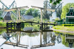 Ponte levatoio e mulini a vento riflessi nelle acque di un canale ad Arnhem, Olanda.

