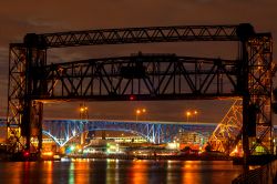 Ponti illuminati di sera sul fiume Cuyahoga nella città di Cleveland, Ohio, USA.


