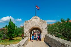 Porta d'ingresso alla storica città di Nin, Croazia. Turisti in visita a una delle località più antiche del paese: fu già abitata in epoca preistorica - © ...