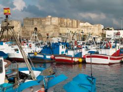 Porto dei pescatori e castello di Guzman a Tarifa, Spagna. Le tradizionali barche da pesca con la bella fortezza che si innalza nella parte più a sud della città - © Andreas ...