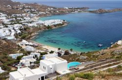 Psarou beach è una delle spiagge dell'isola di Mykons in Grecia. In secondo piano la baia di Platis Gialos - © Panos Karas / Shutterstock.com