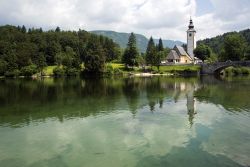 Riflessi della chiesa del Santo Spirito sul lago di Bohinj, Slovenia.



