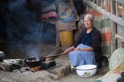 Ritratto di una donna mentre cucina sul fuoco a Cajamarca, Perù - © Christian Vinces / Shutterstock.com

