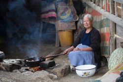 Ritratto di una donna mentre cucina sul fuoco a Cajamarca, Perù - © Christian Vinces / Shutterstock.com

