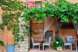 Bar e botteghe si susseguono lungo le strade tra gli edifici color ocra del borgo medievale di Roussillon, nella Francia meridionale -  © Oleg Znamenskiy / Shutterstock.com
