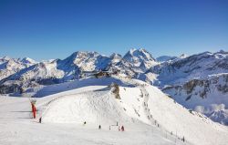 Sciatori e snowboarders nella stazione sciistica di Courchevel, Francia, in una bella giornata invernale di sole.
