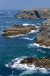 Le scogliere selvagge della costa di Belle Ile en Mer, Francia, con le onde che si infrangono sulle rocce.

