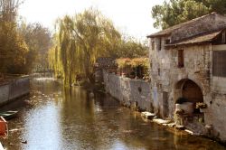 Scorcio bucolico del villaggio di Pons, Francia, con le vecchie case affacciate sul fiume.
