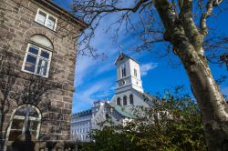 Uno scorcio della chiesa Domkirkjan dai giardini della Casa del Parlamento nel centro di Reykjavik, Islanda - © chrisdorney / Shutterstock.com